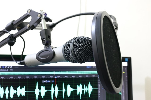 Microphone and computer with audio, image used for Lisa Laporte blog on whether or not podcasts help productivity